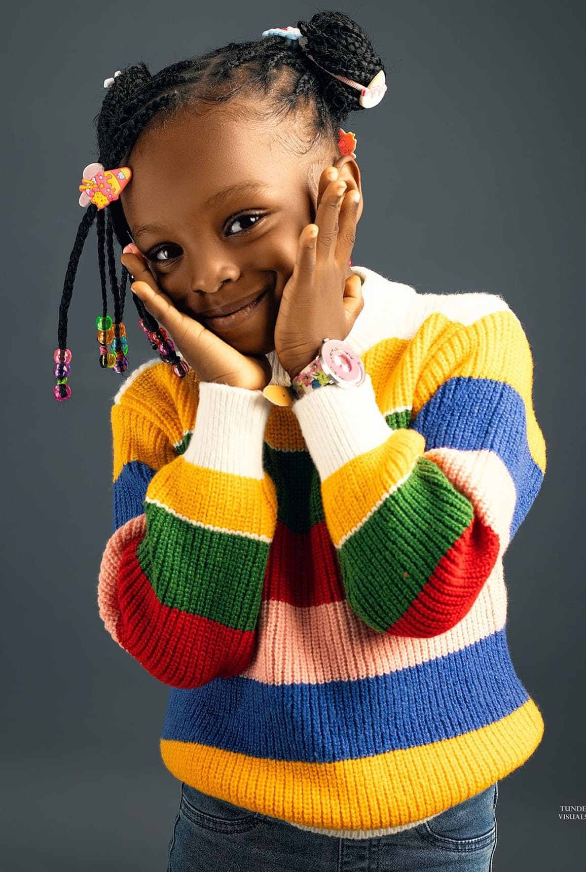 Young child smiling in a colorful striped sweater
